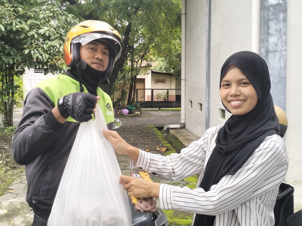 Volunteer BBJ menyerahkan makanan kepada driver Gojek untuk didistribusikan ke yayasan, mendukung pengurangan food waste